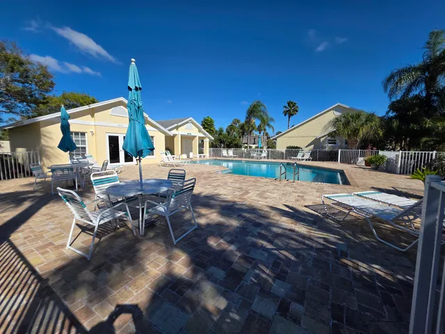 a view of a patio with table and chairs with wooden floor and fence