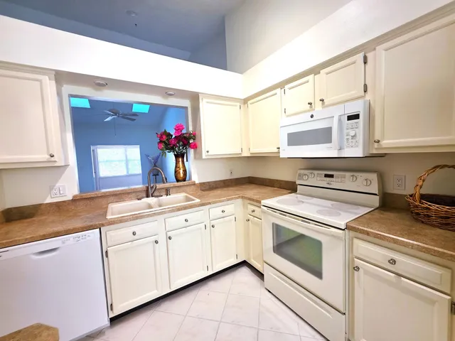 a kitchen with white cabinets and white appliances