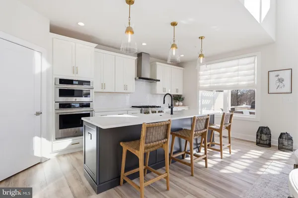 a kitchen with a table chairs microwave and cabinets
