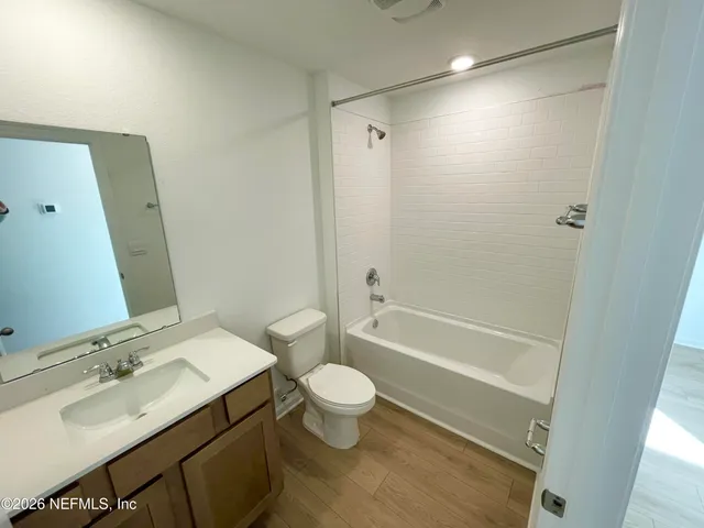 a living room with furniture wooden floor and a large window