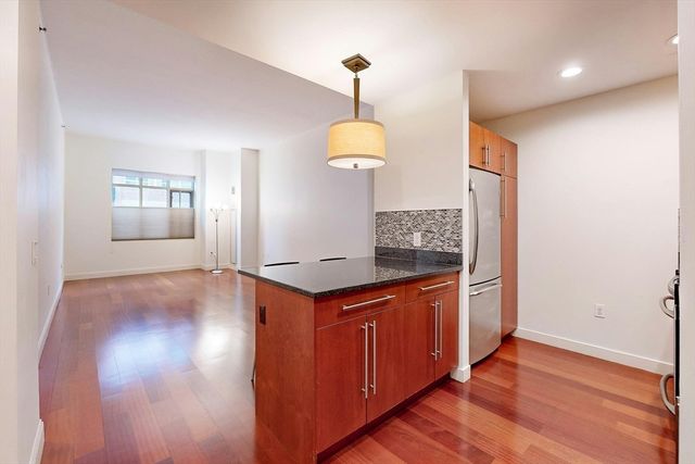 a kitchen with stainless steel appliances granite countertop a stove and a wooden floors