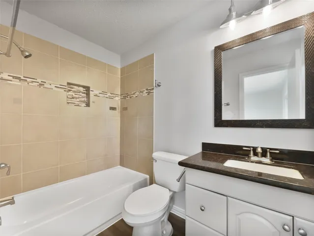 a bathroom with a sink toilet vanity and shower