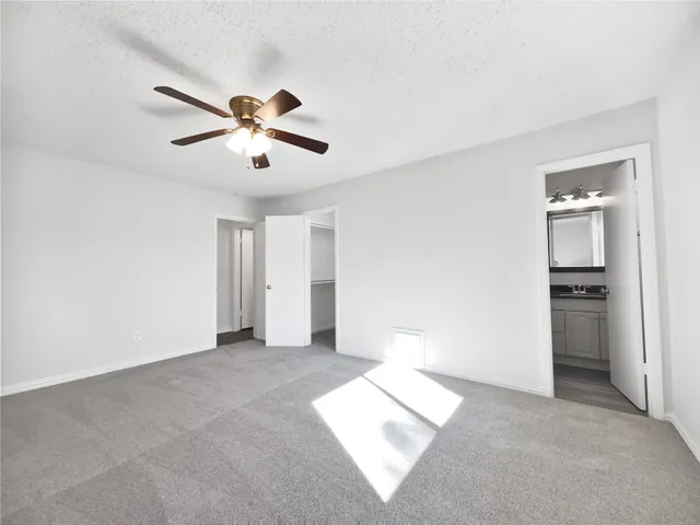 a view of a room with a ceiling fan and a window