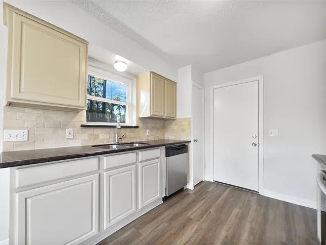 a kitchen with granite countertop white cabinets and a sink