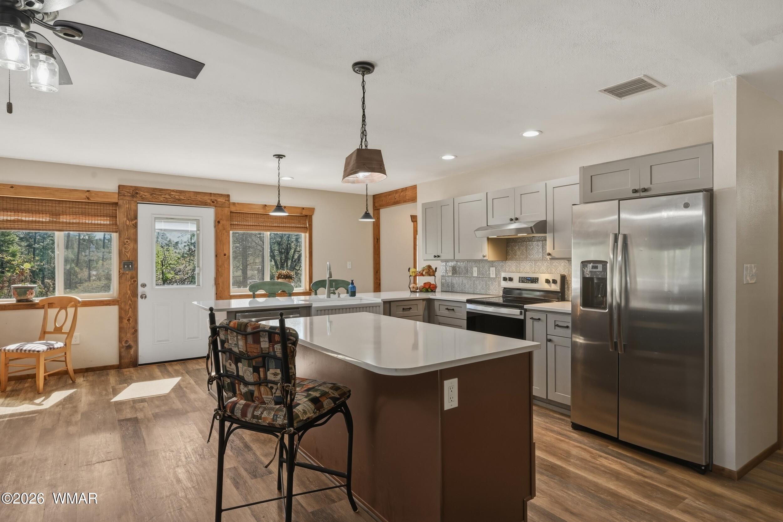 3533 Foothill Road Pine, AZ 85544 - Photo 11 of 52 a kitchen with refrigerator a stove and chairs