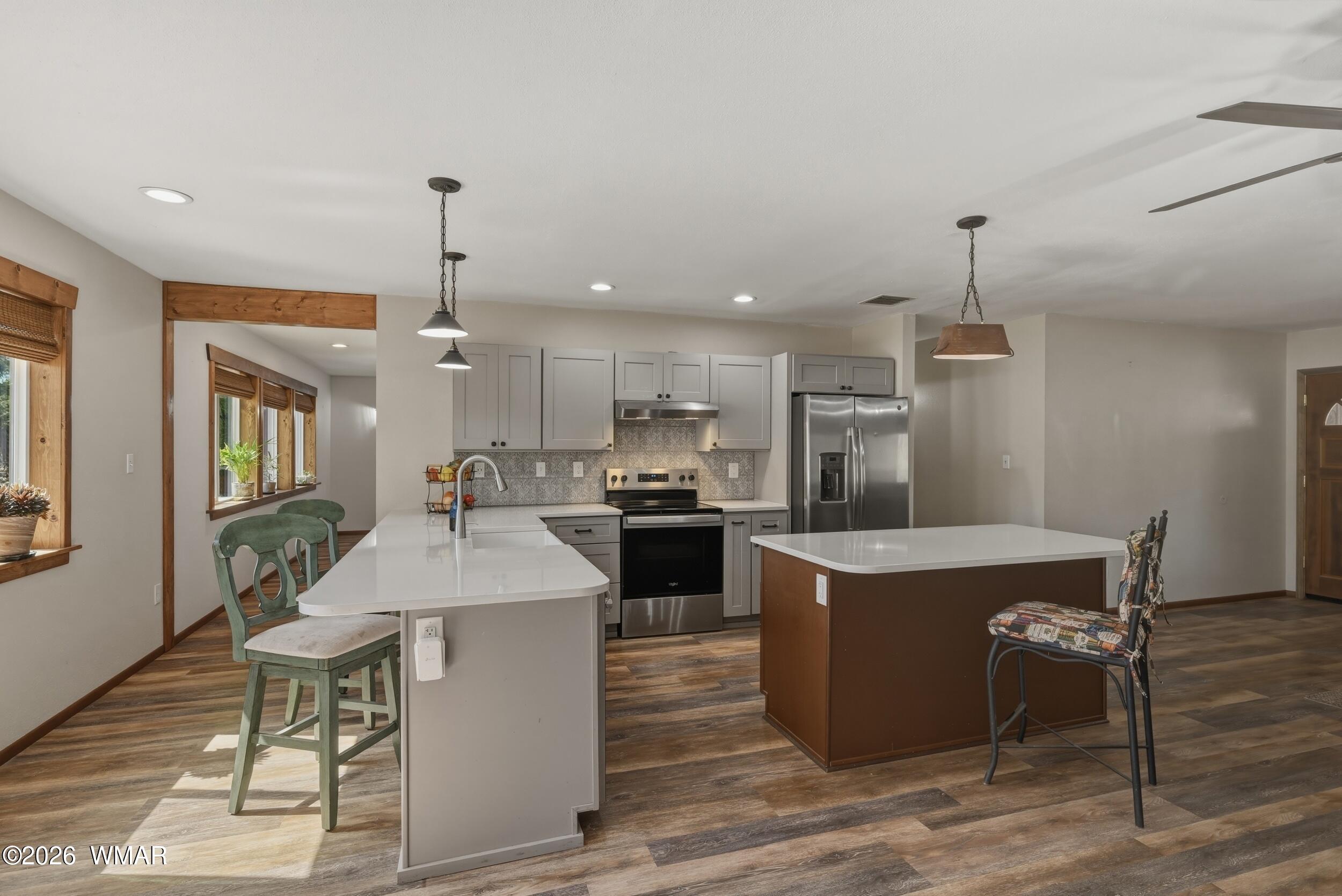 3533 Foothill Road Pine, AZ 85544 - Photo 15 of 52 a kitchen with kitchen island a stove a table and chairs in it