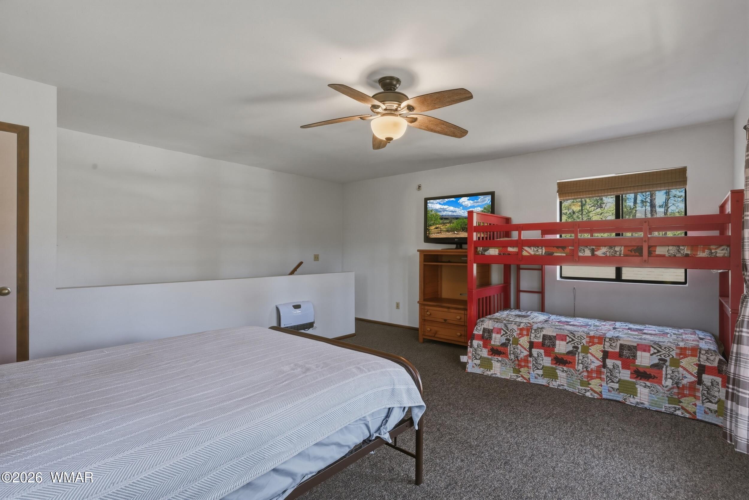3533 Foothill Road Pine, AZ 85544 - Photo 24 of 52 a bedroom with a bed and a chandelier