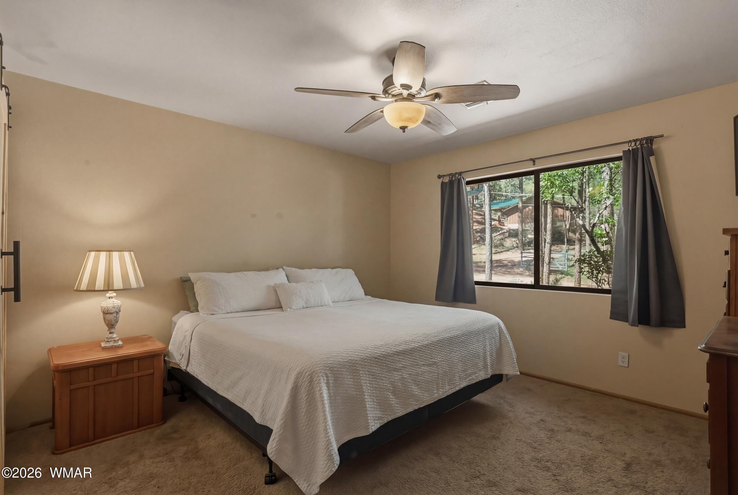 3533 Foothill Road Pine, AZ 85544 - Photo 27 of 52 a bedroom with a large bed and a chandelier