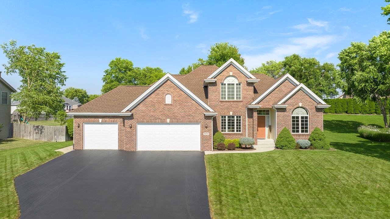 9899 Rambouillet Ridge Roscoe, IL 61073 - Photo 1 of 32 a front view of a house with a yard and garage