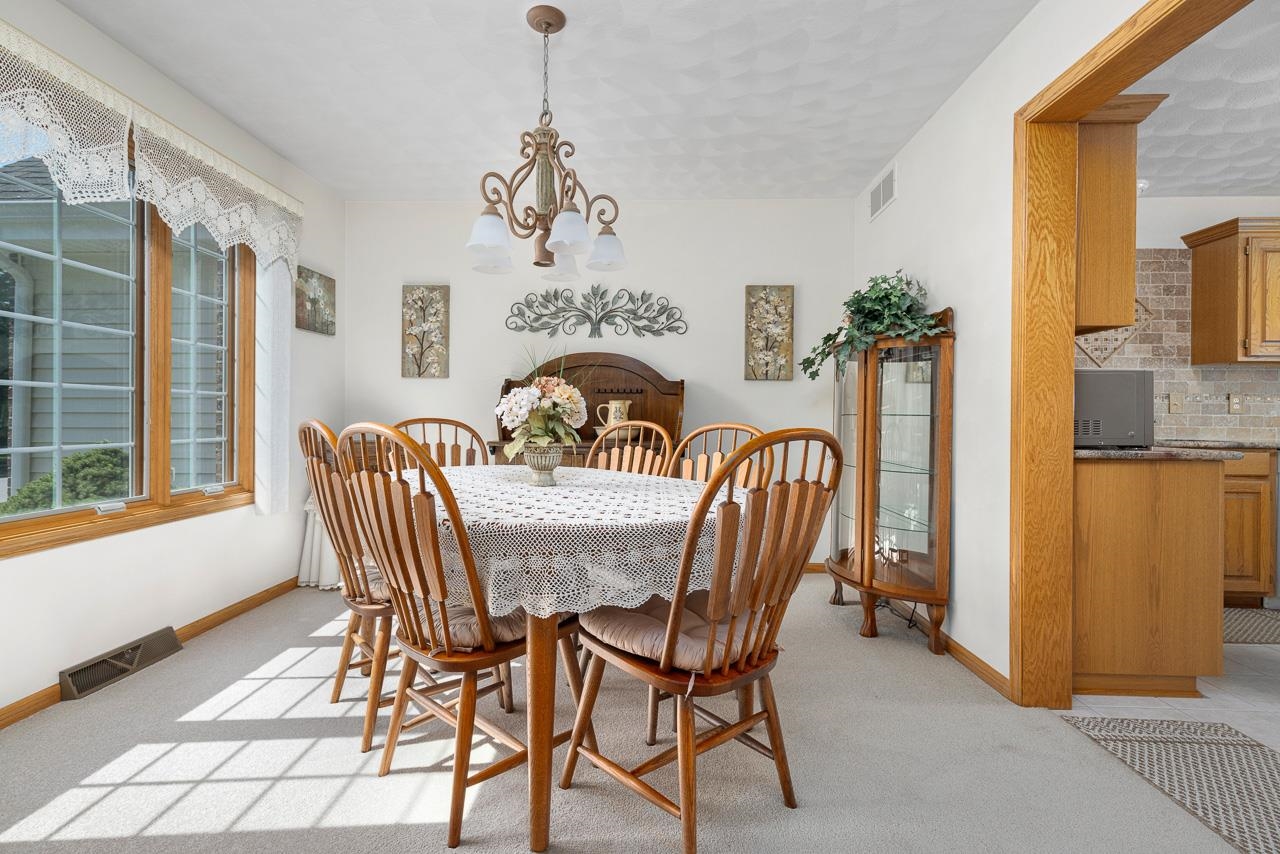 9899 Rambouillet Ridge Roscoe, IL 61073 - Photo 17 of 32 a view of a dining room with furniture window and wooden floor