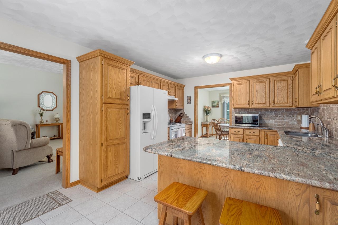 9899 Rambouillet Ridge Roscoe, IL 61073 - Photo 20 of 32 a kitchen with stainless steel appliances granite countertop a refrigerator a stove a sink and dishwasher