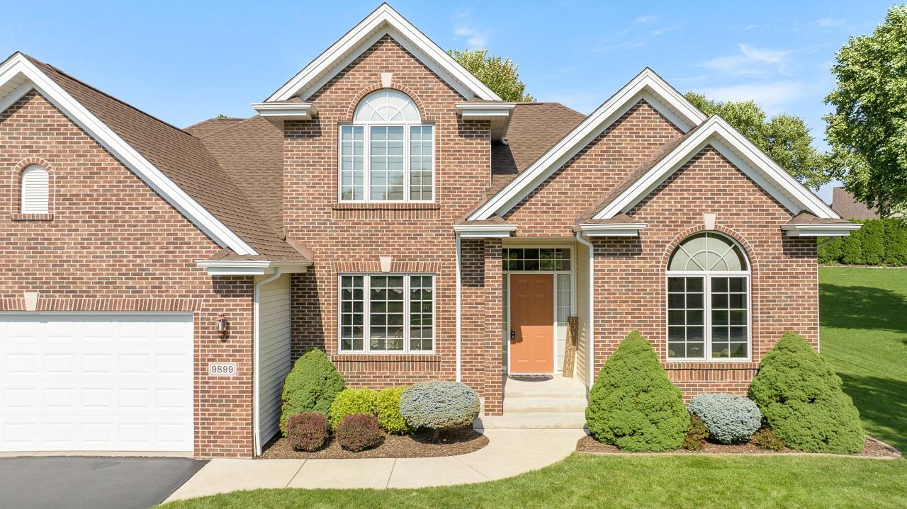 9899 Rambouillet Ridge Roscoe, IL 61073 - Photo 2 of 32 a front view of a house with a yard