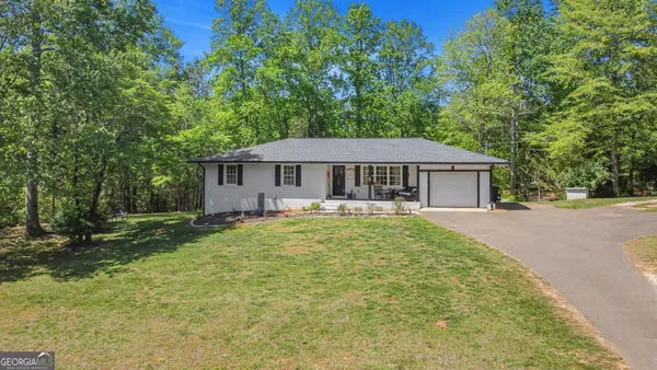 a kitchen with stainless steel appliances granite countertop a refrigerator a stove a sink a dining table and chairs with wooden floor
