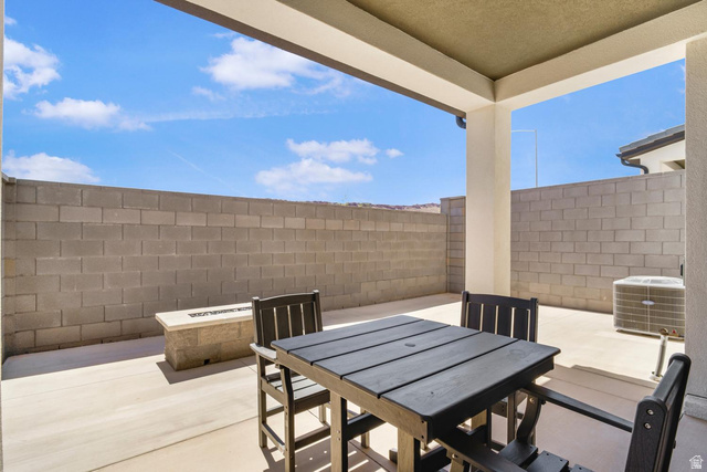 1705 Ripple Rock Drive, Unit 3017 Washington, UT 84780 - Photo 16 of 22 Covered patio with concrete flooring, block wall perimeter, and a built-in fire pit