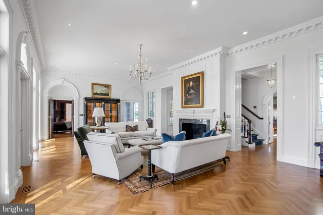 a living room with furniture a chandelier and a flat screen tv