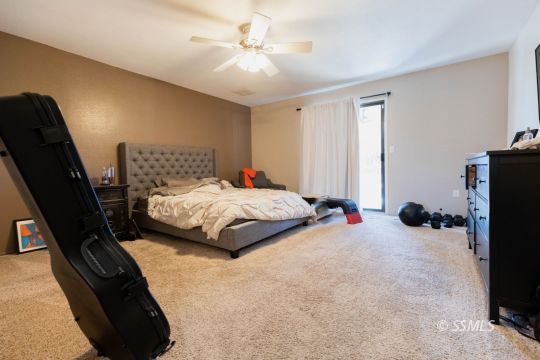 517 Randall Street Ridgecrest, CA 93555 - Photo 22 of 28 a bedroom with a bed a couch and a flat tv screen on the dresser