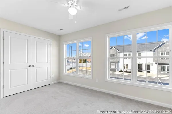 an empty room with fan and entryway