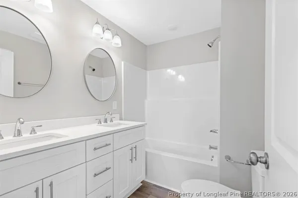 an empty room with windows and ceiling fan