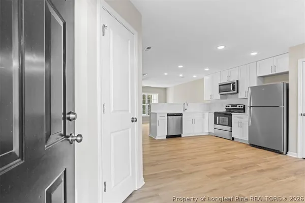a kitchen with granite countertop a refrigerator and a stove top oven