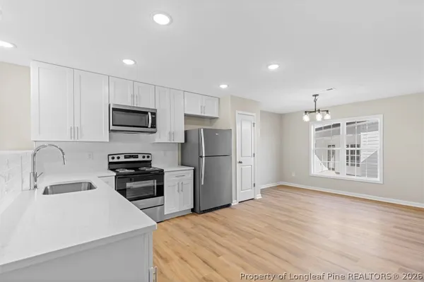 a kitchen with granite countertop a refrigerator and a stove top oven