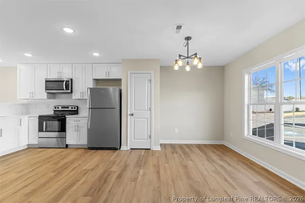a view of a kitchen with wooden floor and a ceiling fan