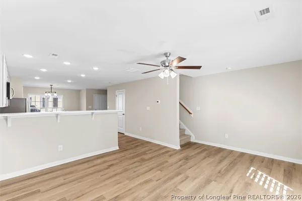 a view of kitchen with refrigerator cabinets and wooden floor