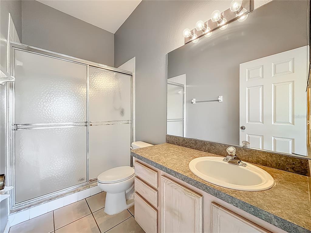 3589 Country Pointe Place Palm Harbor, FL 34684 - Photo 19 of 31 a bathroom with a granite countertop sink toilet a mirror and shower