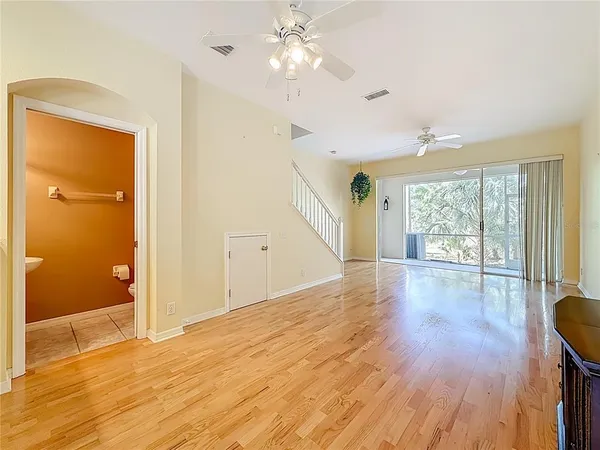 a view of an empty room with wooden floor and a window