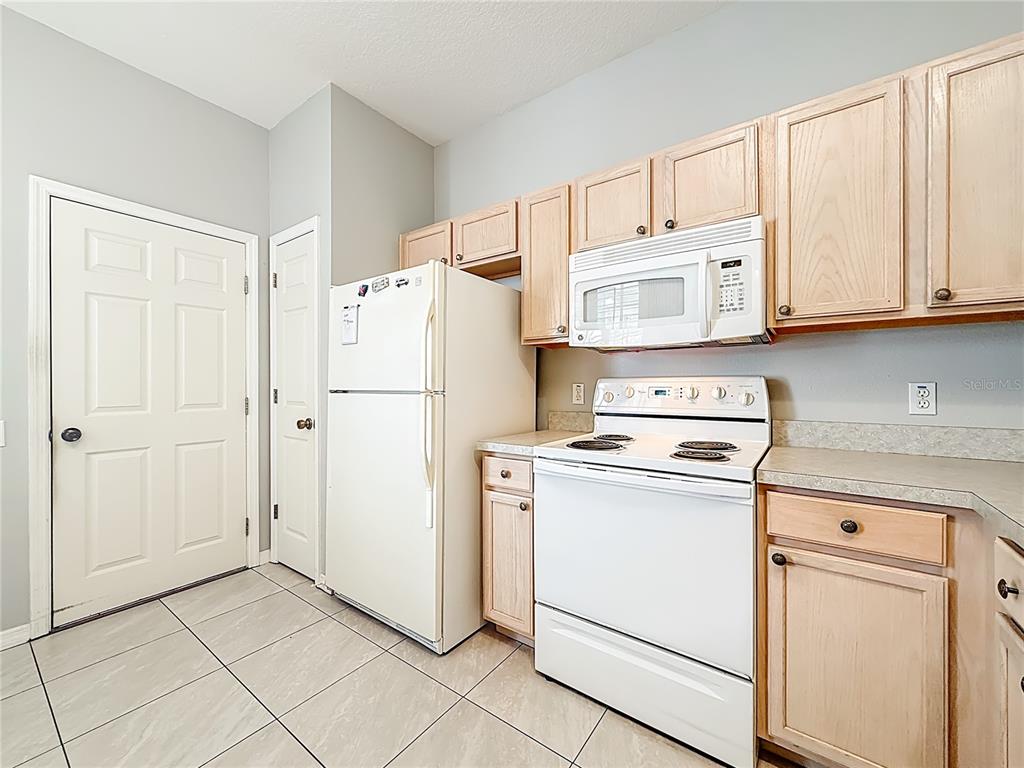 3589 Country Pointe Place Palm Harbor, FL 34684 - Photo 7 of 31 a kitchen with cabinets and a refrigerator