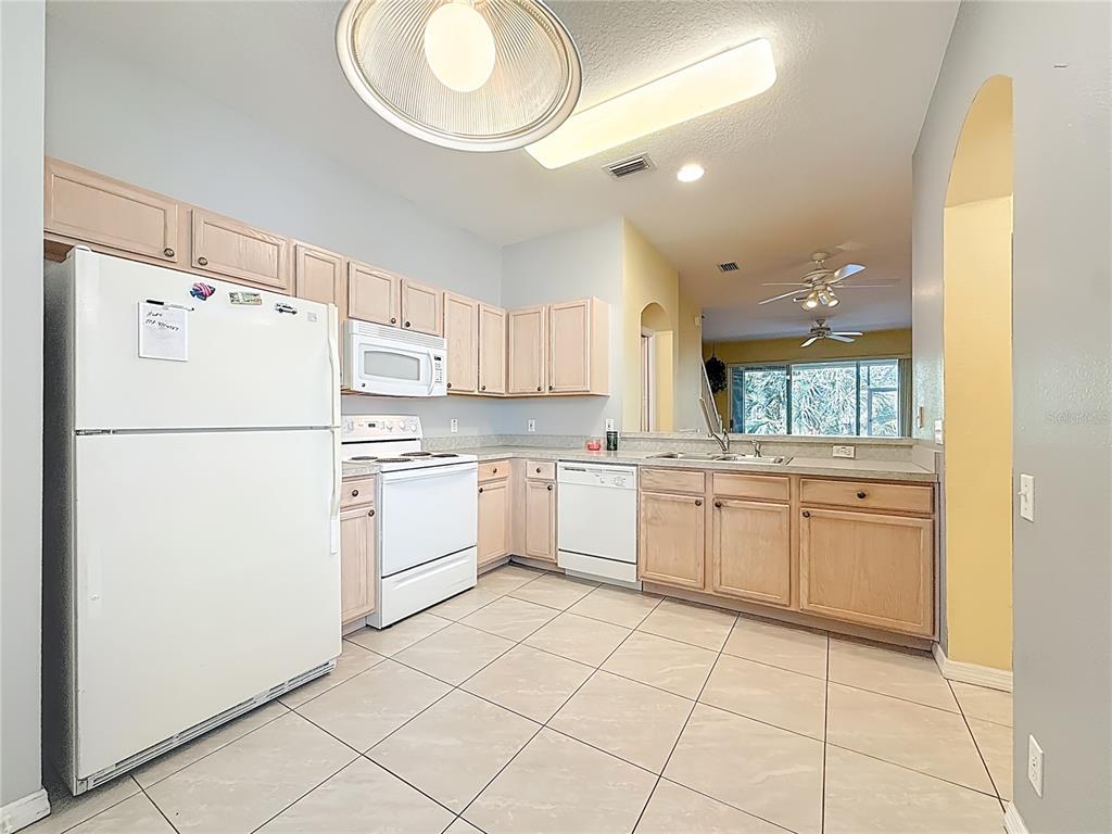 3589 Country Pointe Place Palm Harbor, FL 34684 - Photo 8 of 31 a kitchen with white cabinets and white appliances