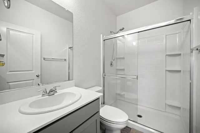 a bathroom with a sink a toilet and shower