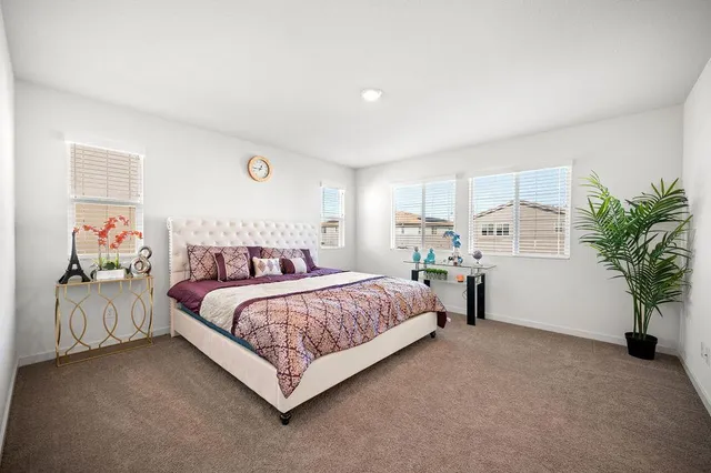 a bedroom with a bed and a potted plant