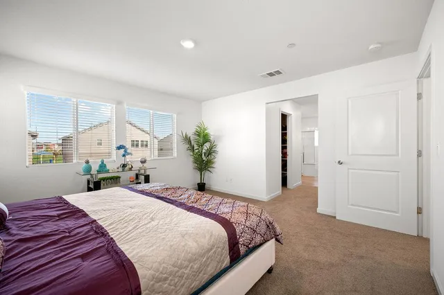 a bedroom with a large bed and potted plant