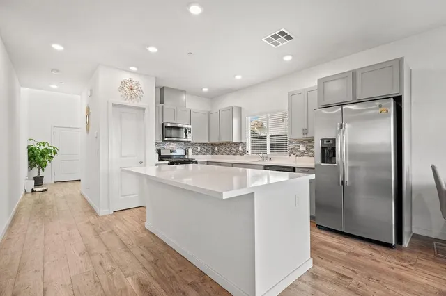 a kitchen with stainless steel appliances granite countertop a refrigerator a sink and a oven