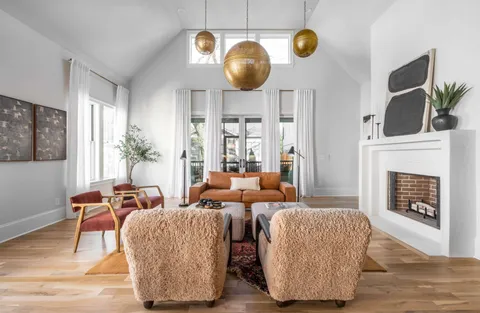 a living room with furniture a fireplace and potted plants