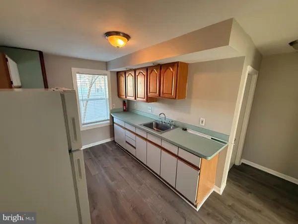 a kitchen with a refrigerator a stove and wooden floor