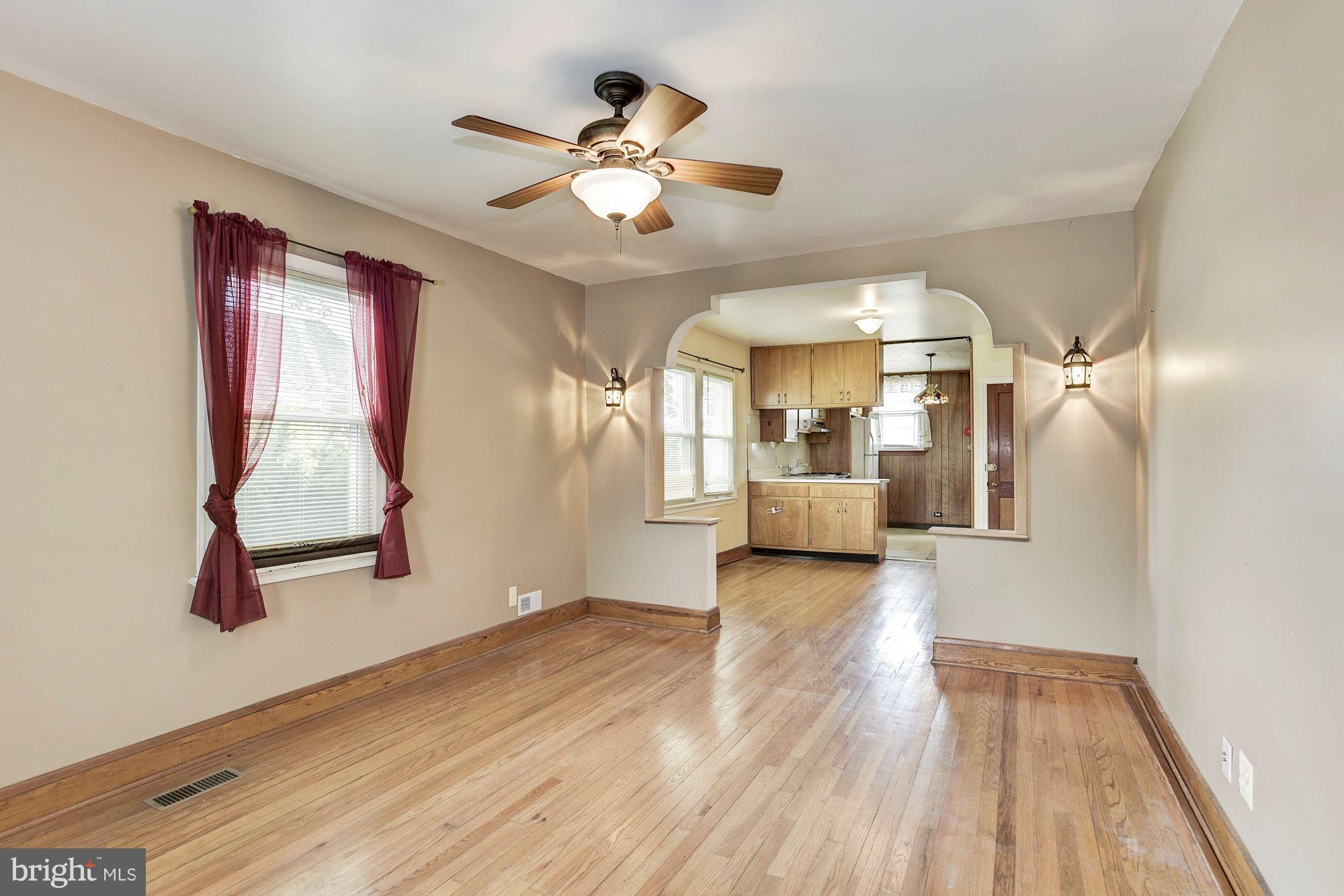 4613 Annapolis Road Baltimore, MD 21227 - Photo 2 of 15 a view of a livingroom with wooden floor and a ceiling fan