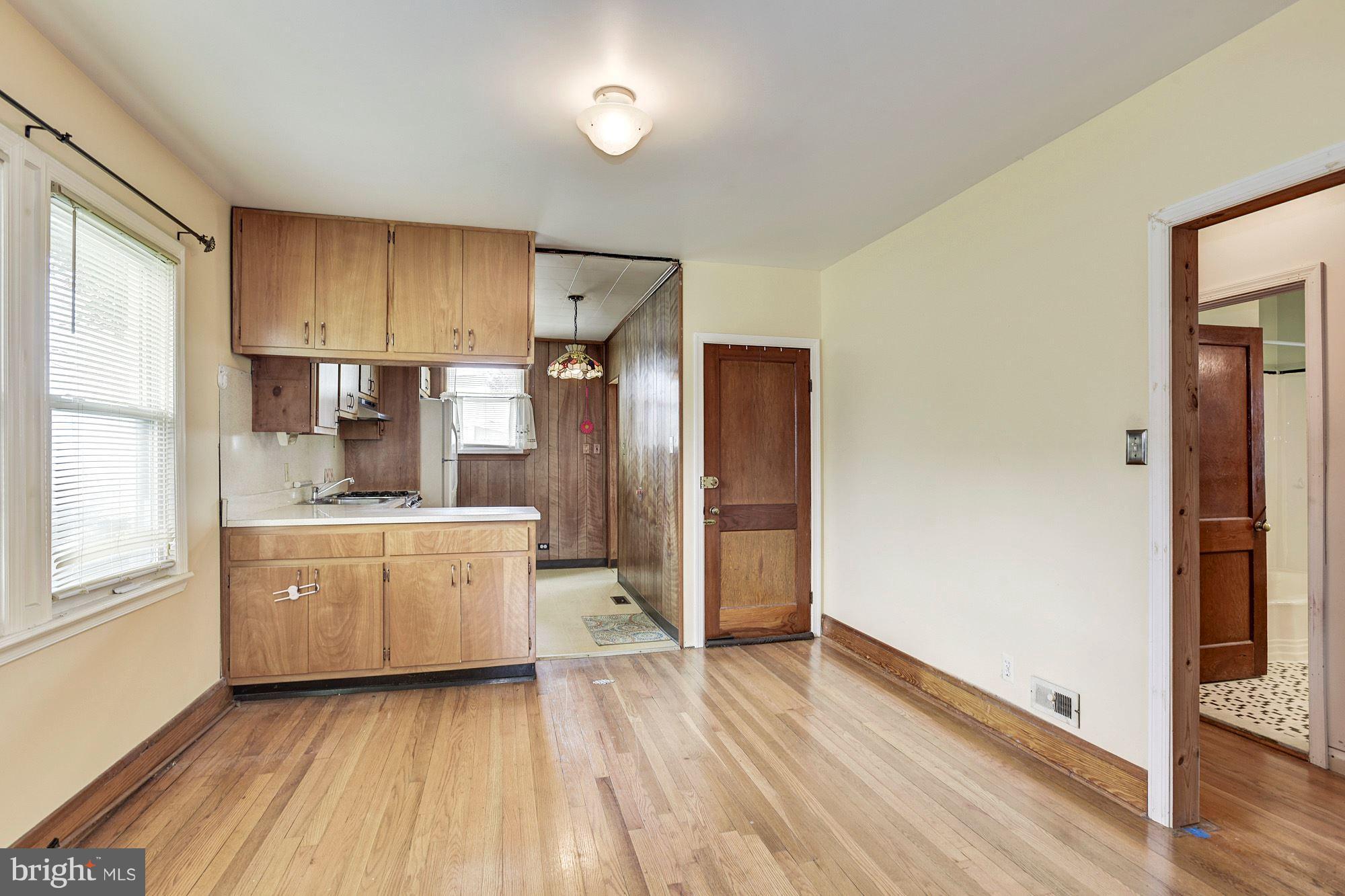 4613 Annapolis Road Baltimore, MD 21227 - Photo 4 of 15 a large kitchen with a refrigerator and wooden floor