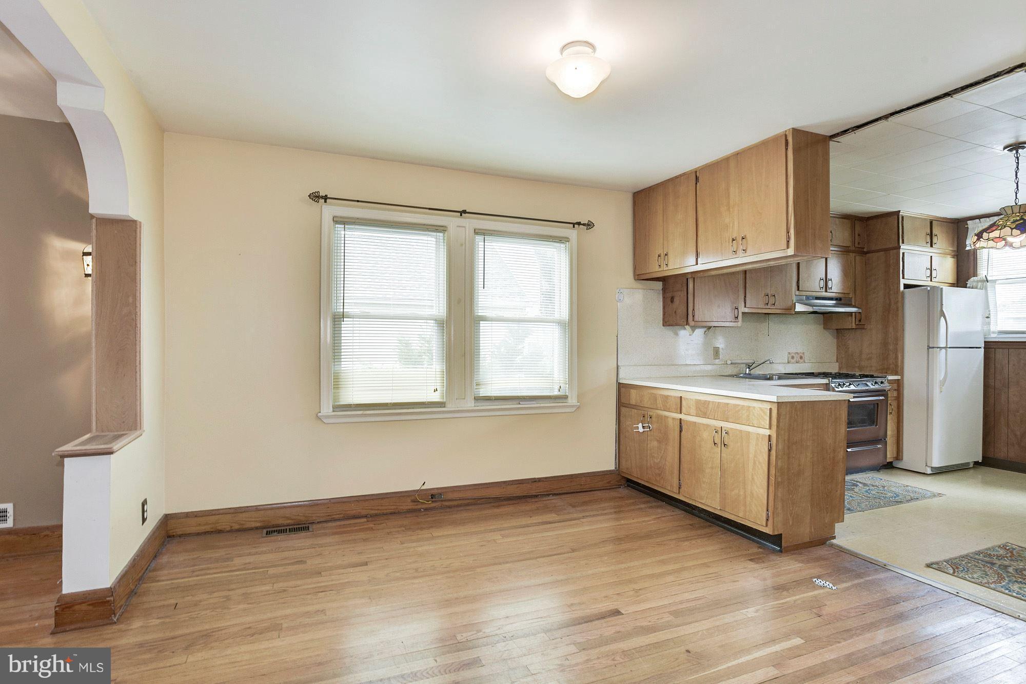 4613 Annapolis Road Baltimore, MD 21227 - Photo 5 of 15 a kitchen with granite countertop white cabinets and wooden floor