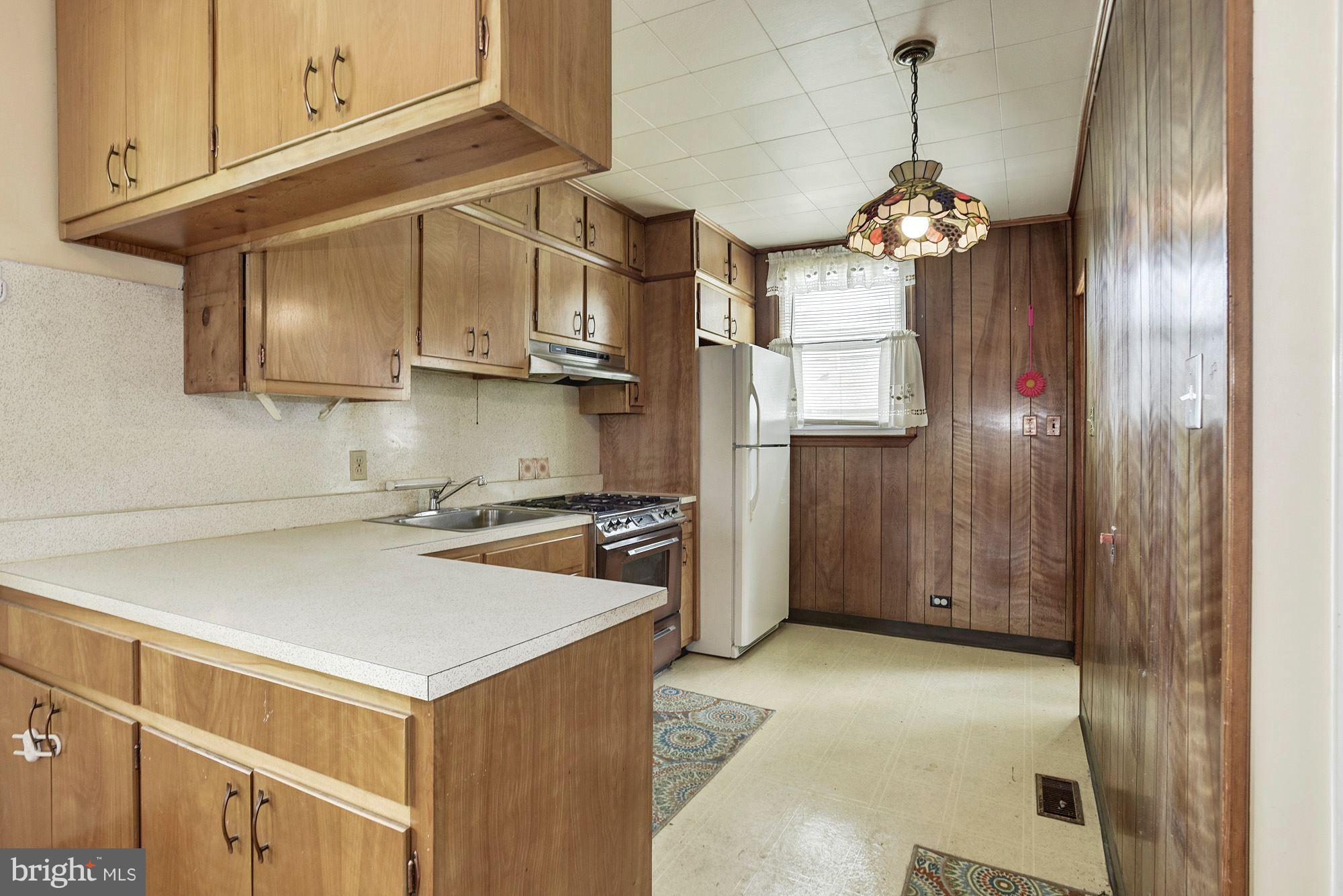4613 Annapolis Road Baltimore, MD 21227 - Photo 6 of 15 a kitchen with a refrigerator a stove a sink and cabinets
