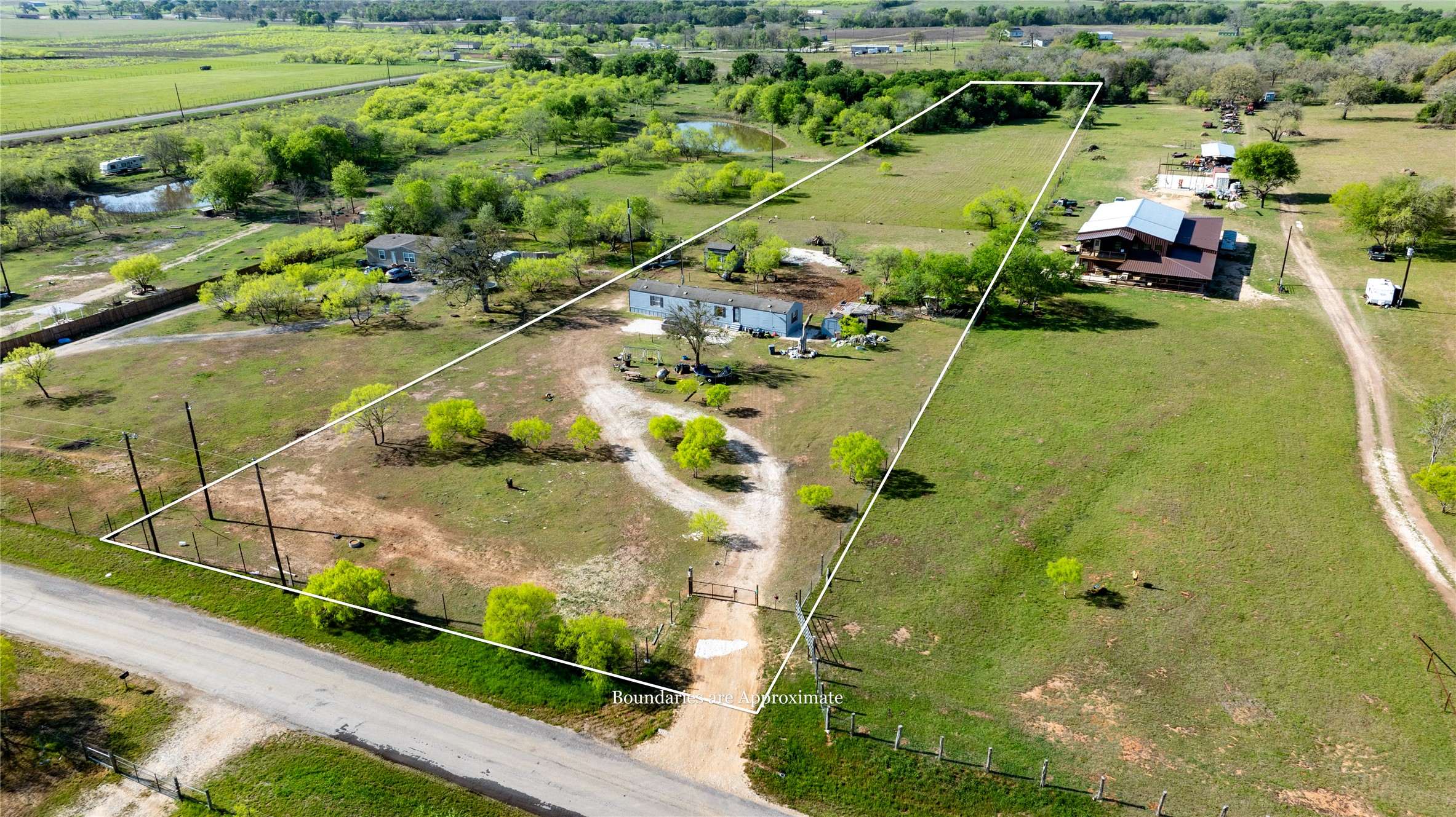 6575 Taylorsville Road Dale, TX 78616 - Photo 11 of 15 An expansive rural property, marked by a defined boundary, offers ample green space and a serene pond.