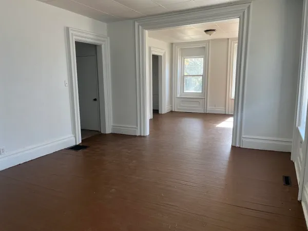 a view of a small space with wooden floor and a window