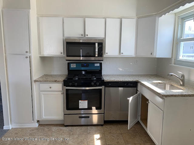 91 Middle Loop Road Staten Island, NY 10308 - Photo 3 of 13 a kitchen with stainless steel appliances granite countertop a stove microwave and sink