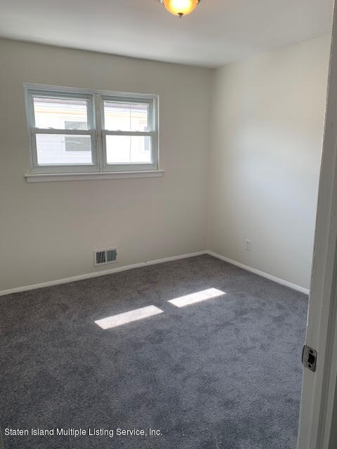 91 Middle Loop Road Staten Island, NY 10308 - Photo 4 of 13 an empty room with a window