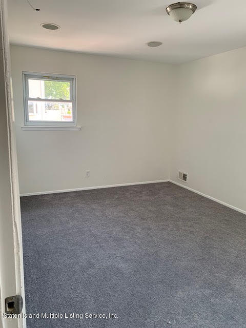 91 Middle Loop Road Staten Island, NY 10308 - Photo 6 of 13 an empty room with a window