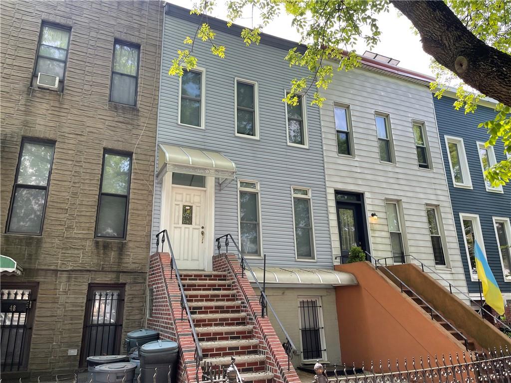 a view of a house with more windows and a tree