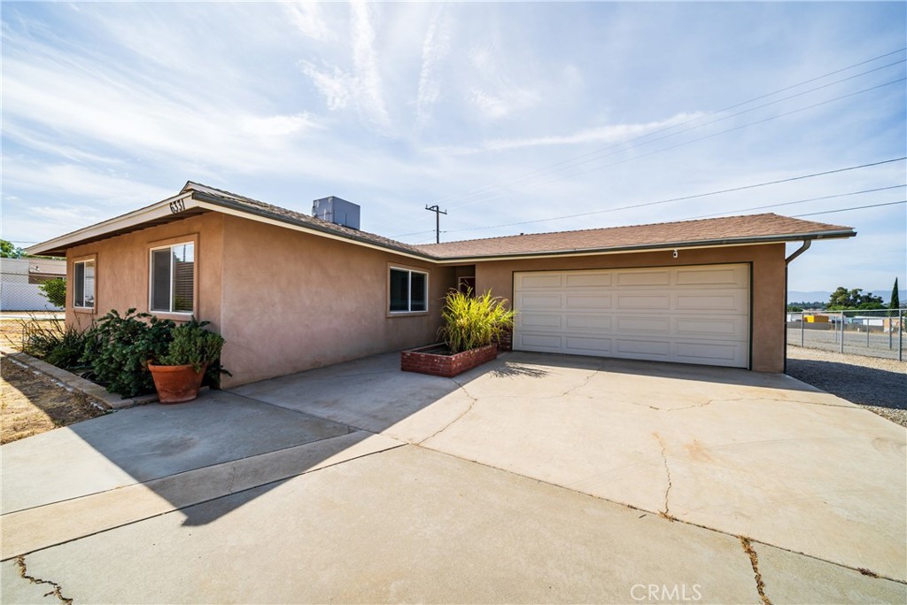 6331 Pedley Road Jurupa Valley, CA 92509 - Photo 22 of 45 a front view of a house with a yard and potted plants