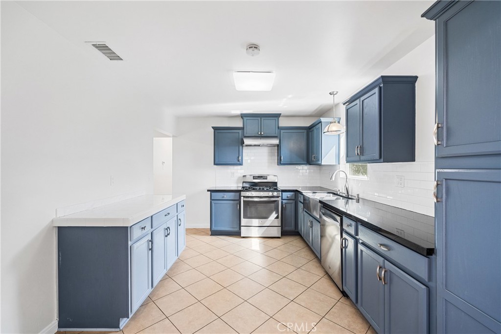 6331 Pedley Road Jurupa Valley, CA 92509 - Photo 38 of 45 a large kitchen with stainless steel appliances granite countertop a sink and cabinets