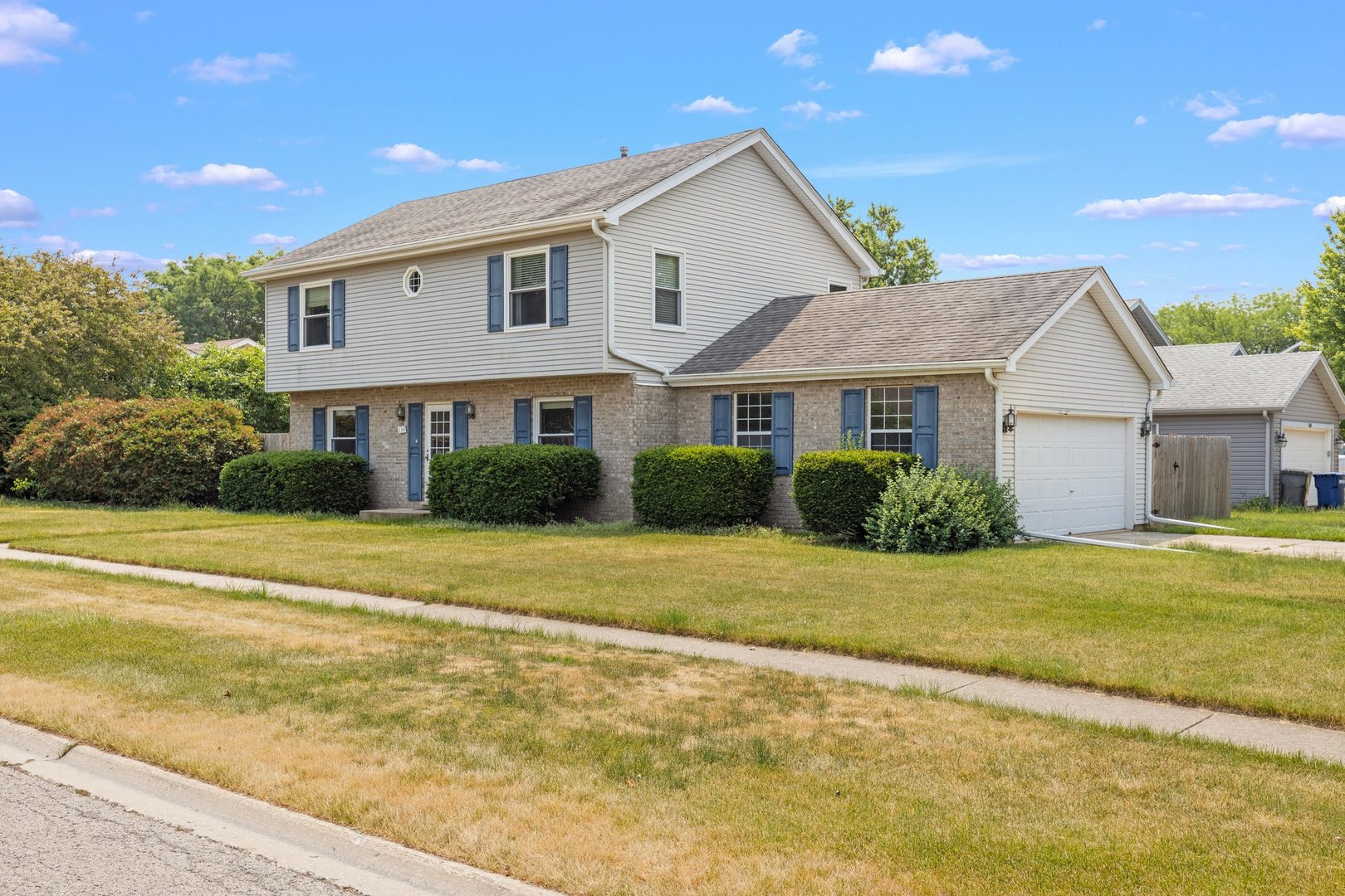 134 Meadows Drive Sugar Grove, IL 60554 - Photo 1 of 20 a front view of a house with a garden