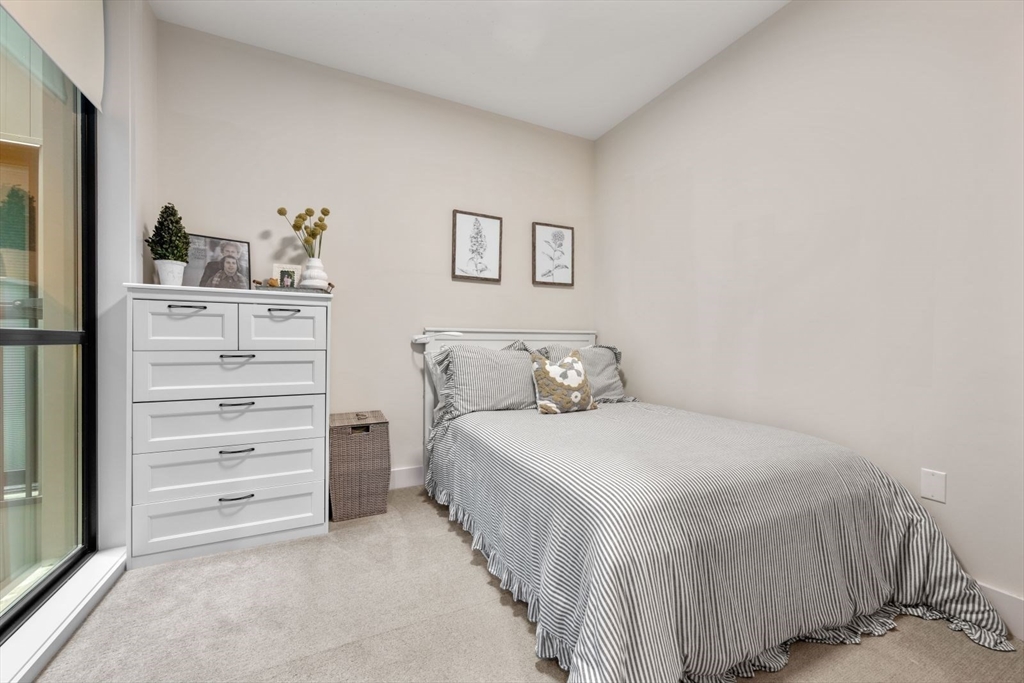 121 Portland Street, Unit 605 Boston, MA 02114 - Photo 13 of 19 a bedroom with a bed and a cabinets